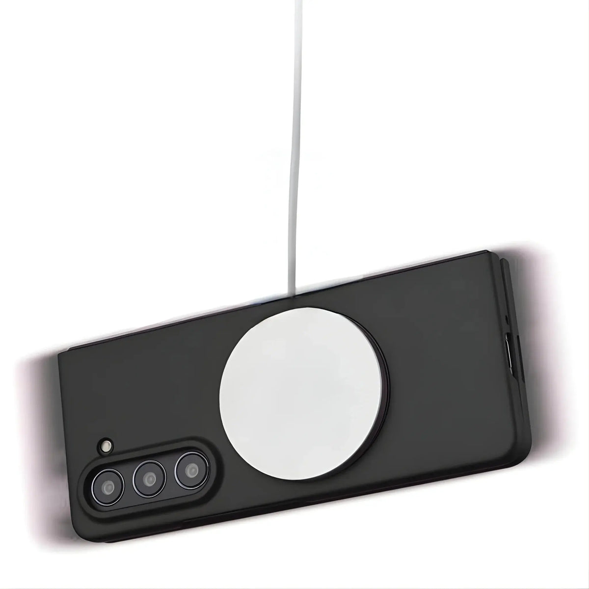 Black smartphone with triple camera and wireless magnetic charger attached via white cable