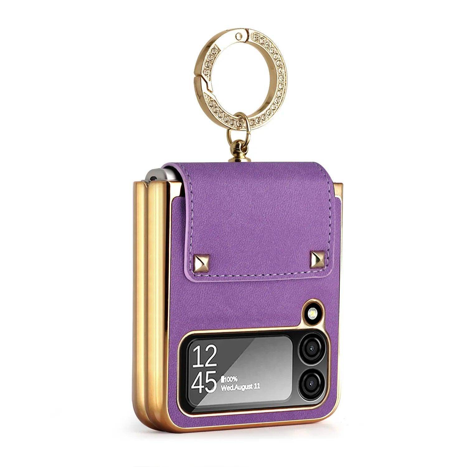 Purple leather flip phone case with gold edges and decorative ring holder featuring rhinestones