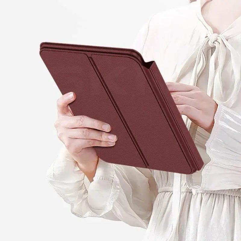 Person holding a tablet with a brown leather folding cover, wearing a white blouse with tied collar