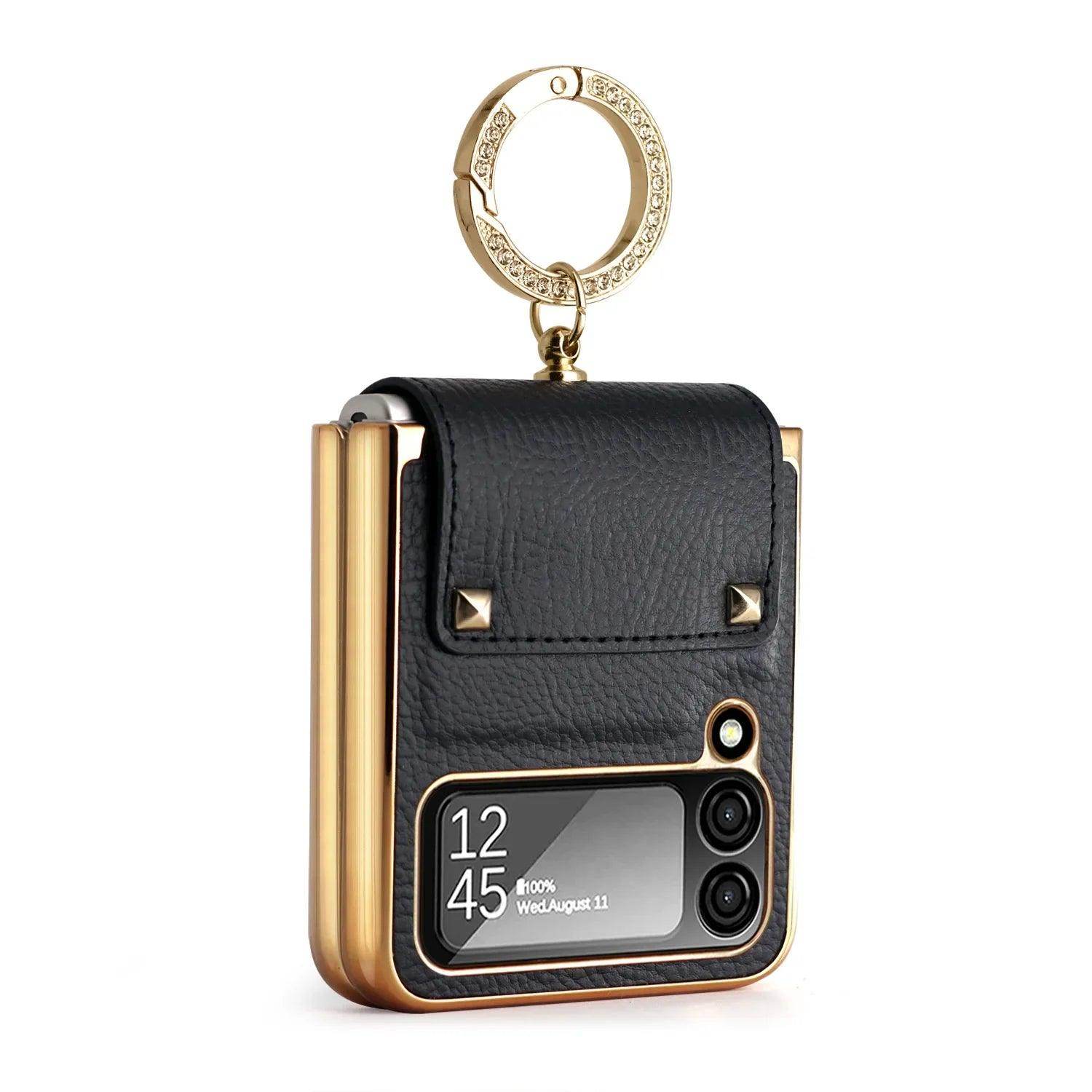 Luxury black leather phone case with gold edges, dual camera cutout, and rhinestone-studded keyring