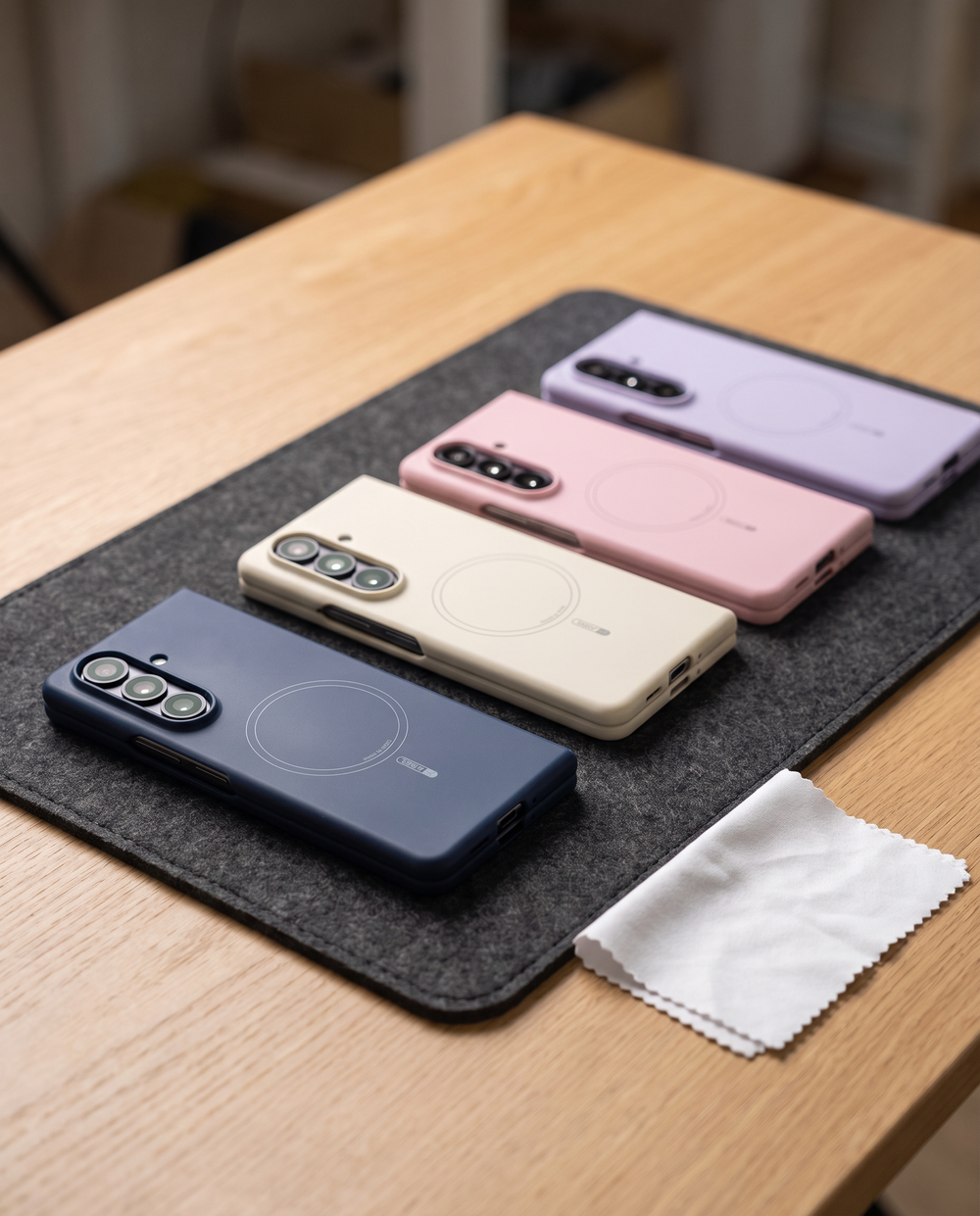 FoldifyCase Apex M3 cases in navy, cream, pink and purple lined up on a felt inspection tray